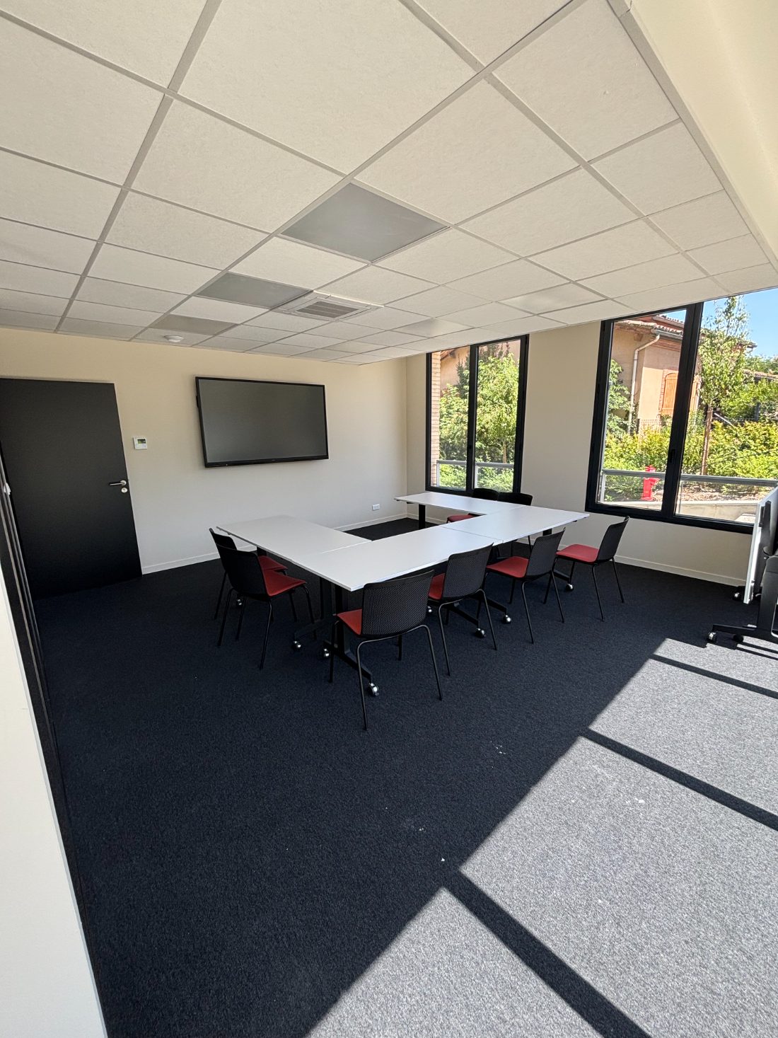 Salle de réunion équipée d'un écran tactile et de la visio IA